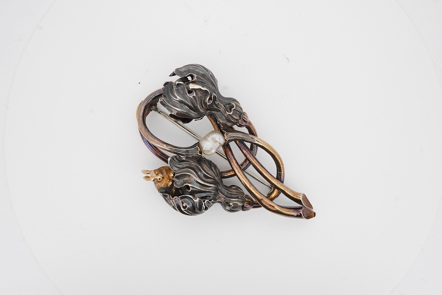 An early 20th century Arts & Crafts yellow and white metal foliate brooch, set with a baroque pearl and later? added rabbit set with cabochon garnet, 67mm. Condition - poor